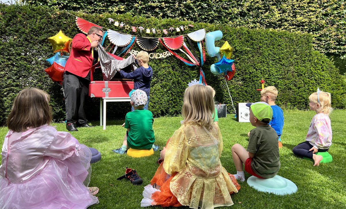Zauberer Salasa beim Kindergeburtstag im Garten – Kinder staunen