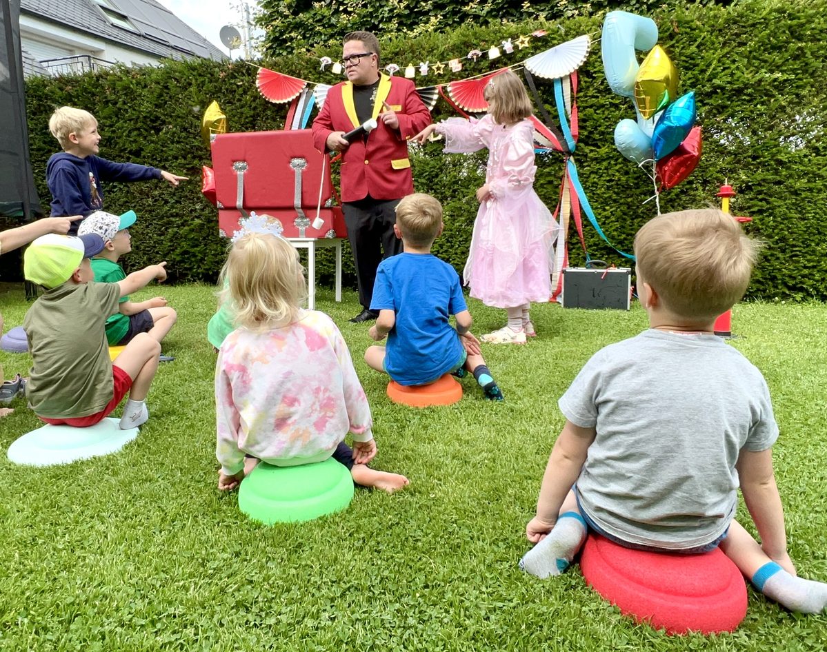 Mädchen hilft dem Zauberer bei einem Trick auf der Geburtstagsfeier